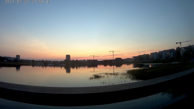 Skärmdump från en actionkamera, där bloggägaren blickar ut över solnedgången och Orrholmen från en bro på Hammaröleden i Karlstad.