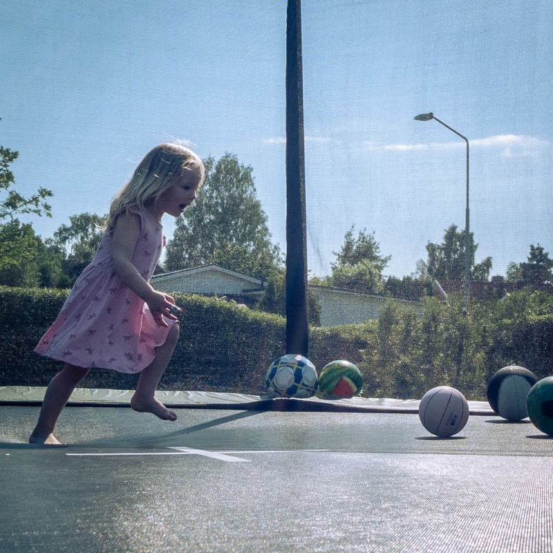 Ett fotografi på brorsdottern Alana när hon leker på studsmattan.